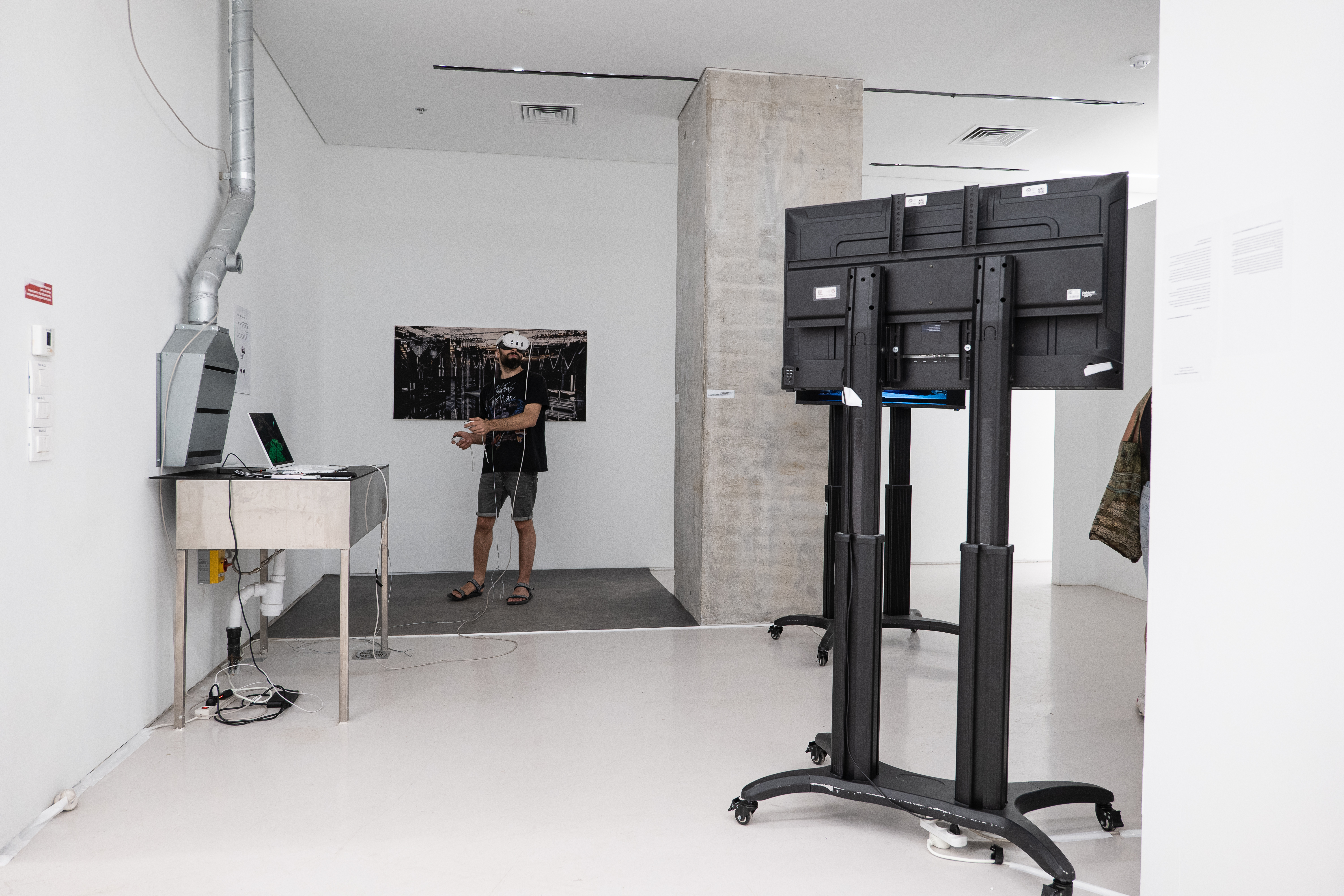 Visitor in VR headset standing in front of a printed work